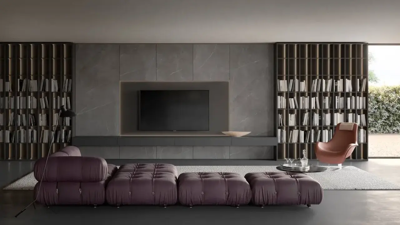 Elegante soggiorno con un moderno tv design integrato in una parete in marmo, librerie a tutta altezza e divano componibile viola.