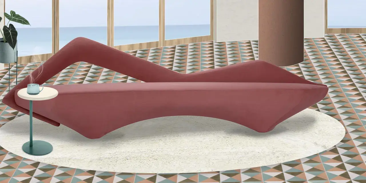 A pink velvet sofa with a unique curved design sits on a cream rug in a room with a geometric tiled floor and a view of the ocean.