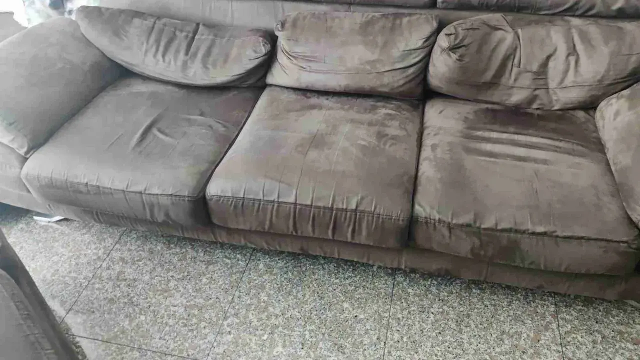 Divano marrone con cuscini un po' affossati, pronti per rifare imbottitura cuscini divano e ridargli vita.