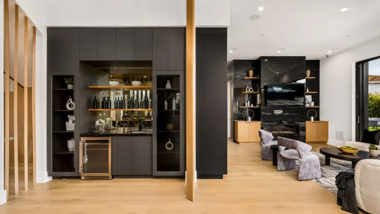 Elegante angolo bar in casa con bottiglie, cantinetta e mensole a vista.