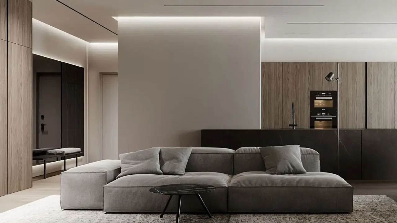 Soggiorno moderno con divano grigio, tavolino nero e cucina a vista. Un pilastro centrale, illuminato da luci a led, offre spunti su come abbellire un pilastro in soggiorno.