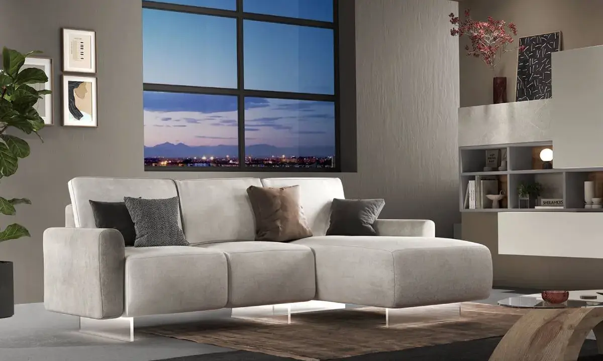 Divano angolare moderno con chaise longue, cuscini decorativi e vista panoramica sulla città al tramonto. Ideale per chi cerca un modo per modificare il proprio salotto.