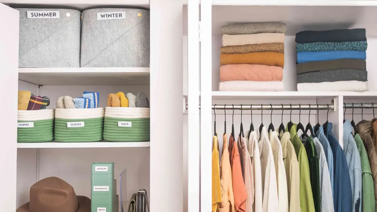 Closet with organized shelves: labeled bins for scarves, gloves, hats, jewelry, bandanas, belts, stacked sweaters, and hanging clothes.