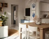 Arredamento casa al mare con idee originali: tavolo in legno, sedie bianche, piante verdi e decorazioni marine.