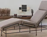 Chaise longue design con struttura in metallo nero e rivestimento in tessuto beige. Un pezzo d'arredo moderno che invita al relax.