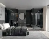Elegante camera da letto con letto grigio scuro, abbinamenti moderni e cabina armadio a vista.