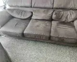 Divano marrone con cuscini un po' affossati, pronti per rifare imbottitura cuscini divano e ridargli vita.