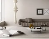 Un angolo relax salotto con chaise longue di design, divano imbottito, tavolino con libro Vogue e un'imponente lampada a sospensione.
