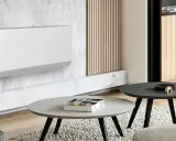 Un moderno termosifone bianco su parete in marmo, un'idea per arredare parete con termosifone in modo elegante. Tavolini e tappeto completano l'arredo.