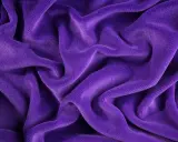Tessuto di velluto viola drappeggiato, morbido e lussuoso. Scopri come lavare il velluto per mantenerlo splendente.