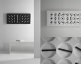Orologio muro design minimalista, con quadrante nero e lancette bianche, e un altro con quadrante bianco e lancette nere.