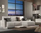 Divano angolare moderno con chaise longue, cuscini decorativi e vista panoramica sulla città al tramonto. Ideale per chi cerca un modo per modificare il proprio salotto.