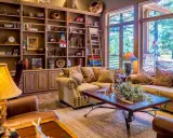 Accogliente soggiorno con libreria in legno, divani imbottiti e un tavolino, perfetto per un arredamento casa campagna.