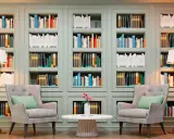 Libreria elegante con libri ordinati, poltrone comode e lampade. Un'ispirazione su come abbellire una libreria con stile e funzionalità.