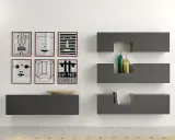 Parete con sei stampe astratte, mensole **Minottitalia** grigie con bottiglie e libri, lampada da terra.