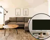 Salotto accogliente con divano angolare, tavolino e un'inquadratura che mostra la tv non frontale al divano, con decorazioni.