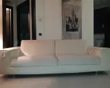Un comodo divano bianco, perfetto per rilassarsi, con un quadro di New York alle spalle. I divani Bosal sono sinonimo di comfort.
