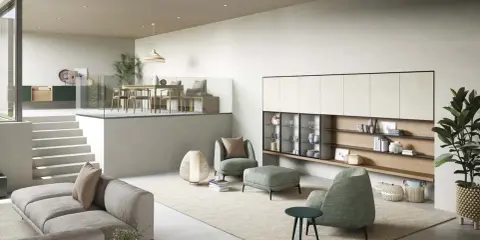 Accogliente zona giorno piccola con divano grigio, poltrone verdi e un piano rialzato con tavolo da pranzo.