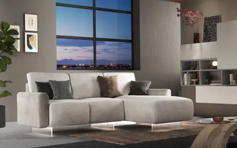 Divano angolare moderno con chaise longue, cuscini decorativi e vista panoramica sulla città al tramonto. Ideale per chi cerca un modo per modificare il proprio salotto.