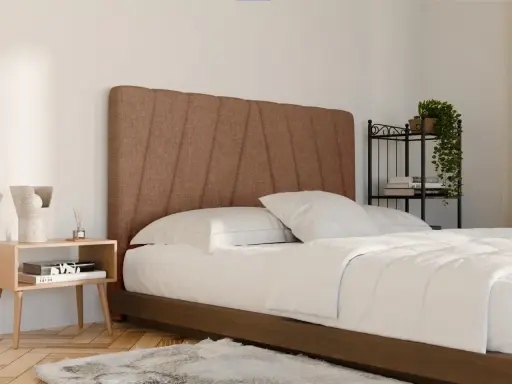 Un letto in tessuto marrone con testiera imbottita, lenzuola bianche e comodino in legno. Ideale per chi cerca consigli su come pulire letto in tessuto.