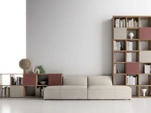 Un comodo divano beige è posizionato davanti a una libreria modulare in legno, con libri e oggetti decorativi.