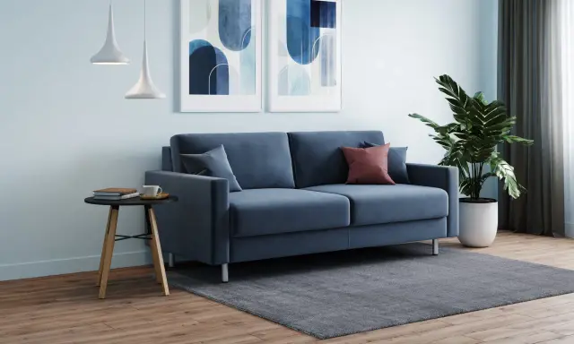 Soggiorno moderno con divano blu, quadri astratti e piante. L'altezza mensole sopra divano è ideale per l'arredo.