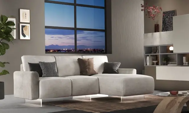 Divano angolare moderno con chaise longue, cuscini decorativi e vista panoramica sulla città al tramonto. Ideale per chi cerca un modo per modificare il proprio salotto.