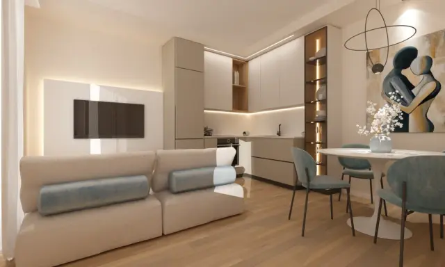 Soggiorno beige e bianco con divano, cucina moderna, tavolo rotondo e quadro astratto.