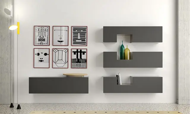Parete con sei stampe astratte, mensole **Minottitalia** grigie con bottiglie e libri, lampada da terra.