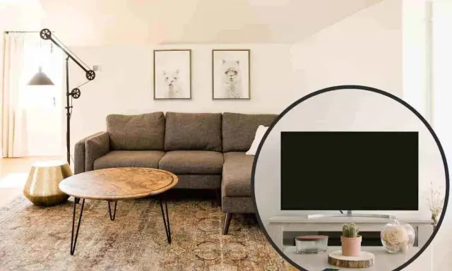 Salotto accogliente con divano angolare, tavolino e un'inquadratura che mostra la tv non frontale al divano, con decorazioni.