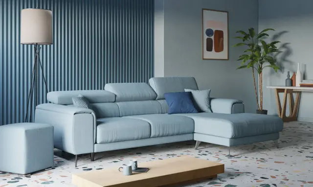 Accogliente soggiorno con divano angolare azzurro, tavolino in legno, lampada da terra e pianta.