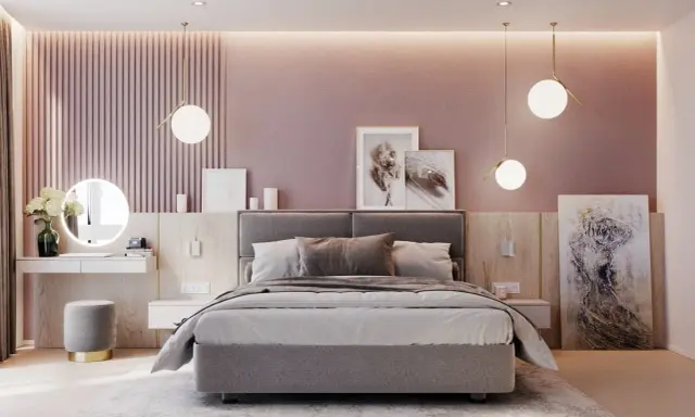 Elegante camera da letto rosa antico e grigio con letto imbottito, specchio rotondo illuminato e opere d'arte astratte.