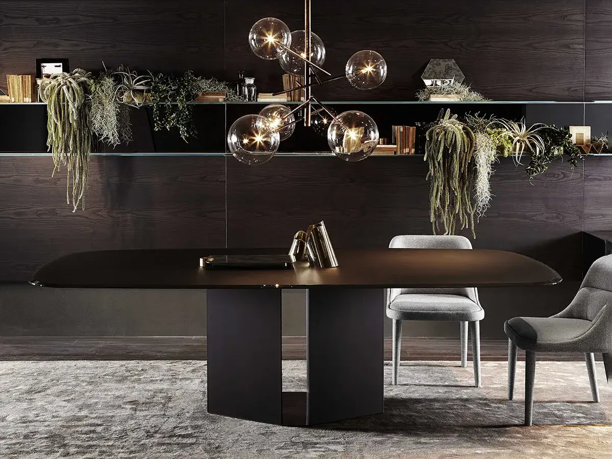 Tavolo ovale moderno Gallotti & Radice con sedie grigie, illuminato da un lampadario a sfere e circondato da piante pensili.