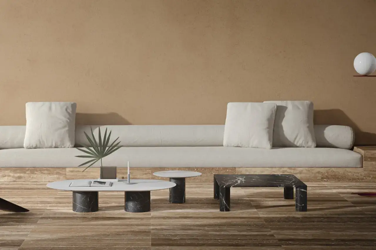 Soggiorno moderno con divano chiaro, tavolini in marmo e pavimento in legno. Un esempio di come abbinare i colori per un ambiente sofisticato.