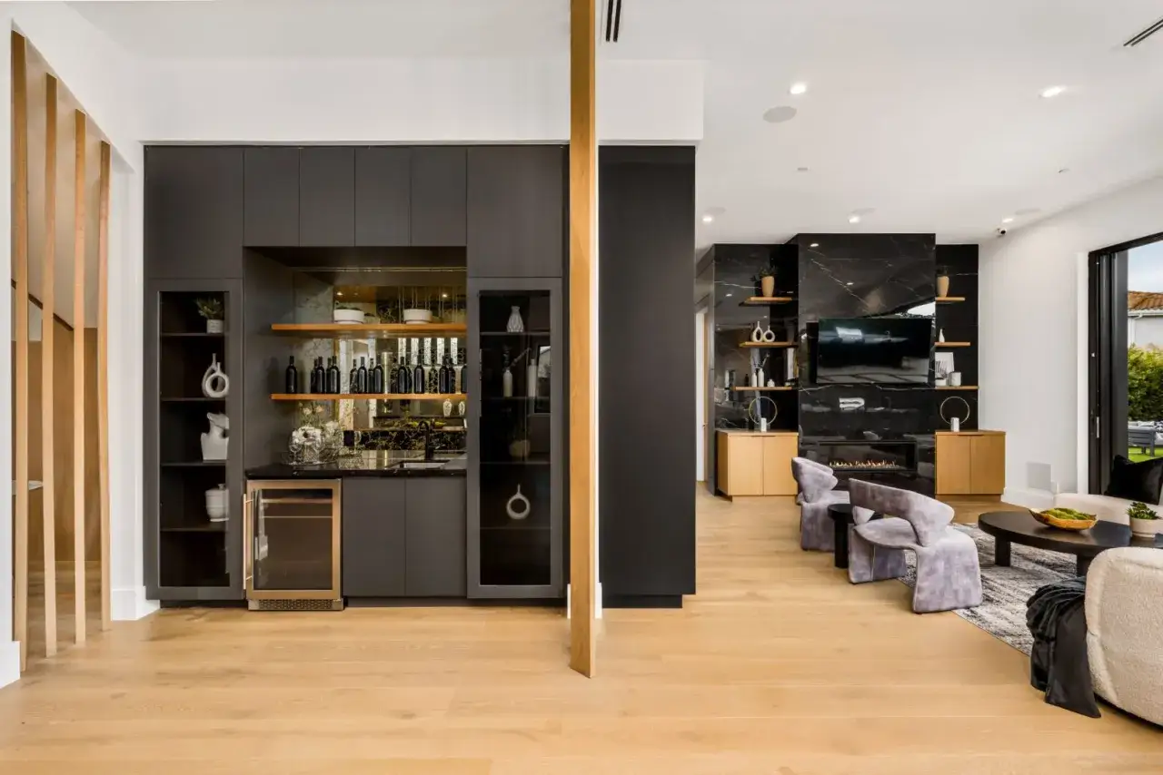 Elegante angolo bar in casa con bottiglie, cantinetta e mensole.