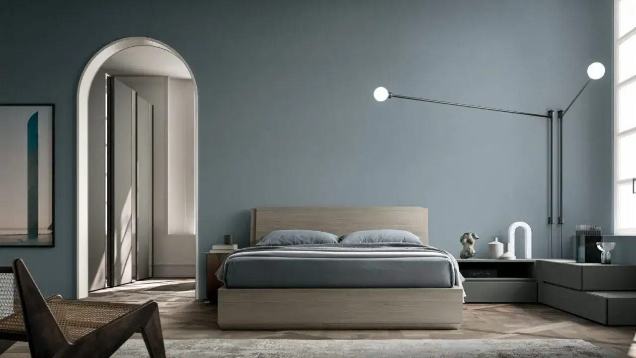 Camera da letto moderna con pareti blu polvere, letto in legno chiaro e arredi minimalisti. Idee per pareti camera da letto moderna.