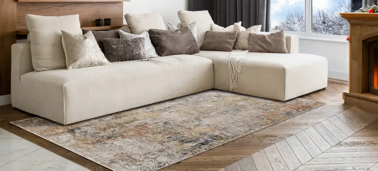 Un soggiorno accogliente: divano beige, tappeto effetto vintage e camino acceso. Idee per arredare con stile e calore.