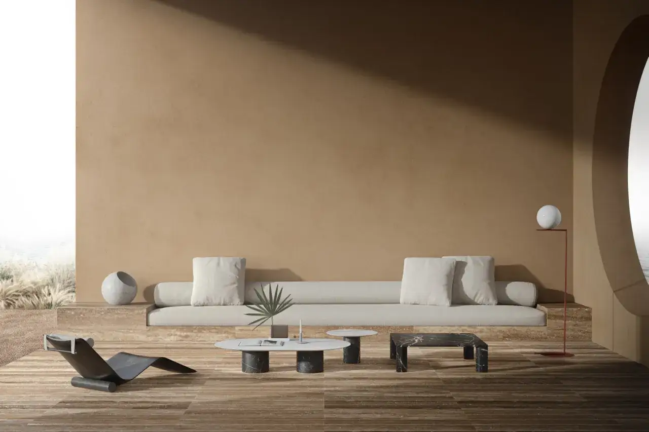 Soggiorno minimalista con divano lungo, chaise longue, tavolini in marmo e lampada a sfera. Ispirazione per come arredare casa con stile.