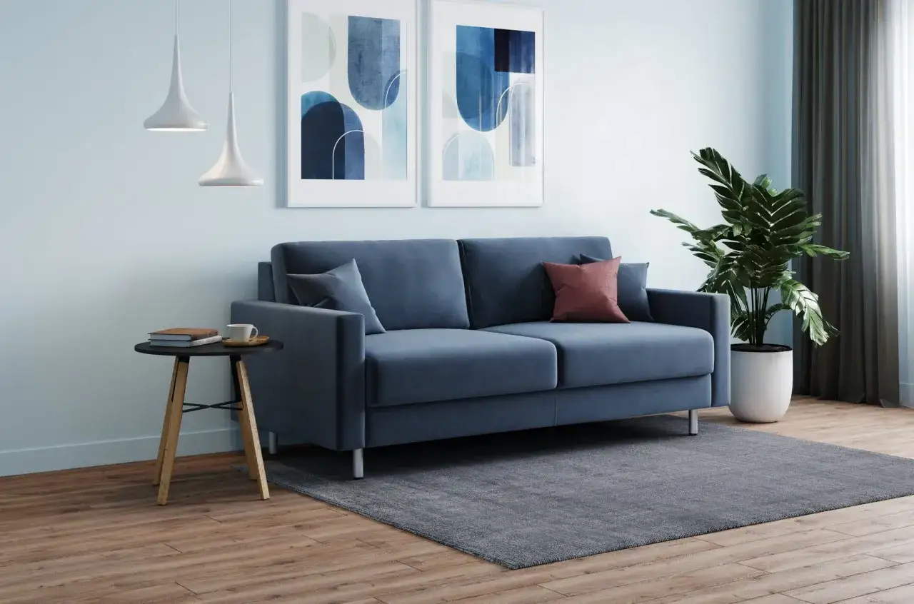 Soggiorno moderno con divano blu, quadri astratti e lampade a sospensione. L'altezza mensole sopra divano è ideale per l'arredo.
