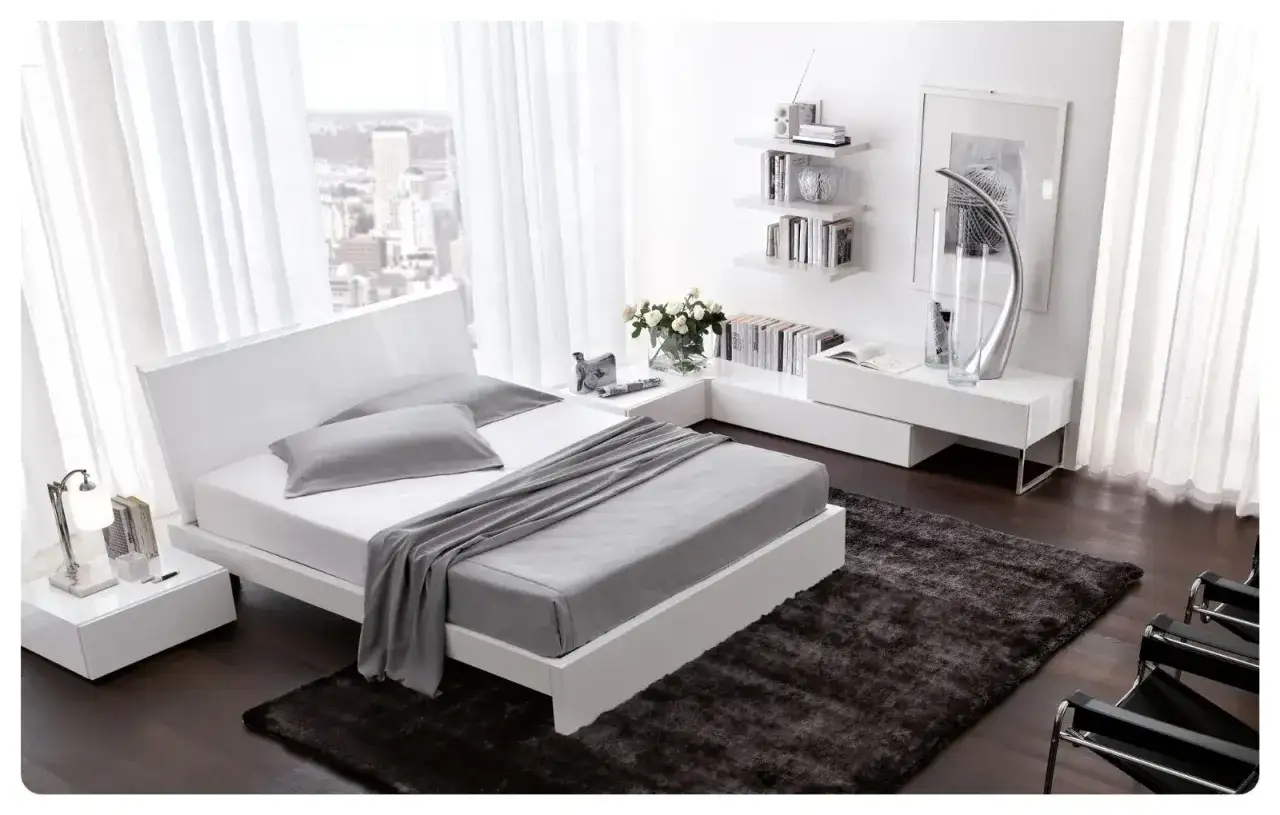 Moderna camera da letto bianca con letto minimalista, comodini, libreria a muro e tappeto scuro. Idee camera da letto bianca per un ambiente luminoso.