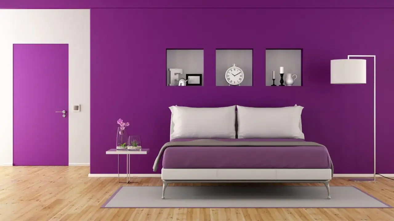 Camera da letto con pareti viola intenso, un letto moderno e una porta coordinata. I colori pareti camera da letto feng shui sono pensati per creare armonia.