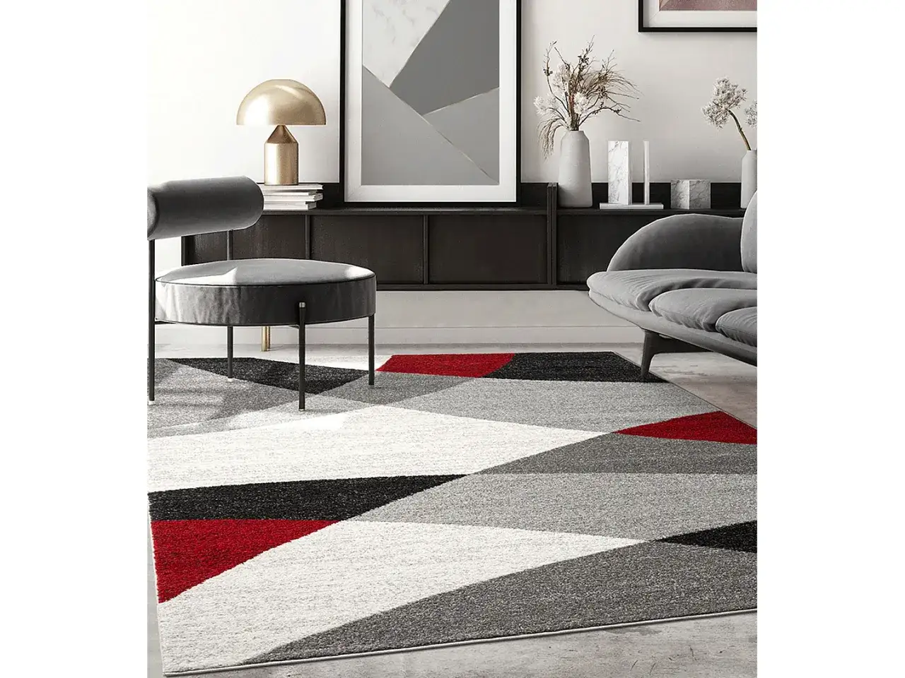 Tappeto geometrico con motivi grigio e rosso, che aggiunge un tocco moderno a un salotto con mobili scuri e un divano grigio.
