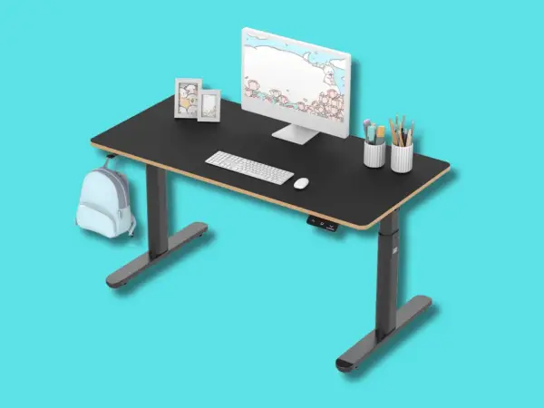Tavolino gaming nero regolabile in altezza, con monitor, tastiera, mouse, porta penne e zainetto azzurro appeso.