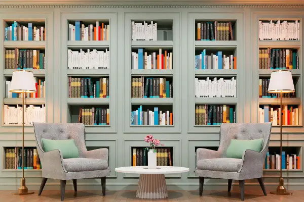 Libreria elegante con libri ordinati, poltrone comode e lampade. Un'ispirazione su come abbellire una libreria con stile e funzionalità.