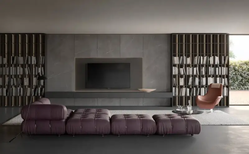 Elegante soggiorno con un moderno tv design integrato in una parete in marmo, librerie a tutta altezza e divano componibile viola.