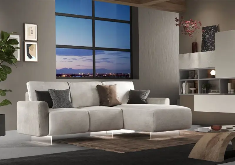 Divano angolare moderno con chaise longue, cuscini decorativi e vista panoramica sulla città al tramonto. Ideale per chi cerca un modo per modificare il proprio salotto.