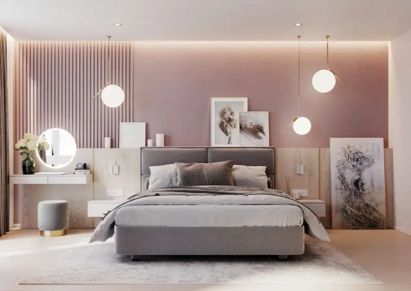 Elegante camera da letto rosa antico e grigio con letto imbottito, specchio rotondo illuminato e opere d'arte astratte.